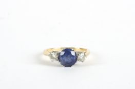 A three stone diamond and sapphire ring, with centre set sapphire in claw setting flanked by two