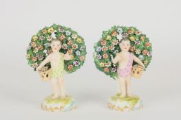 A pair of 19th century Samson of Paris Chelsea style bocage groups, formed as cherubs holding