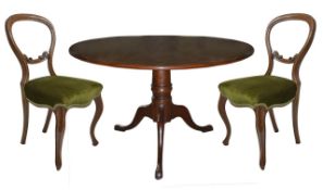 A Georgian design mahogany circular dining table and six Victorian dining chairs, the plain tilt