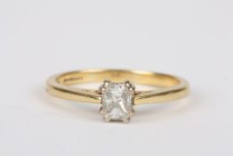 An 18ct gold and diamond solitaire ring, set with emerald cut diamond of approximately 0.25 cts in