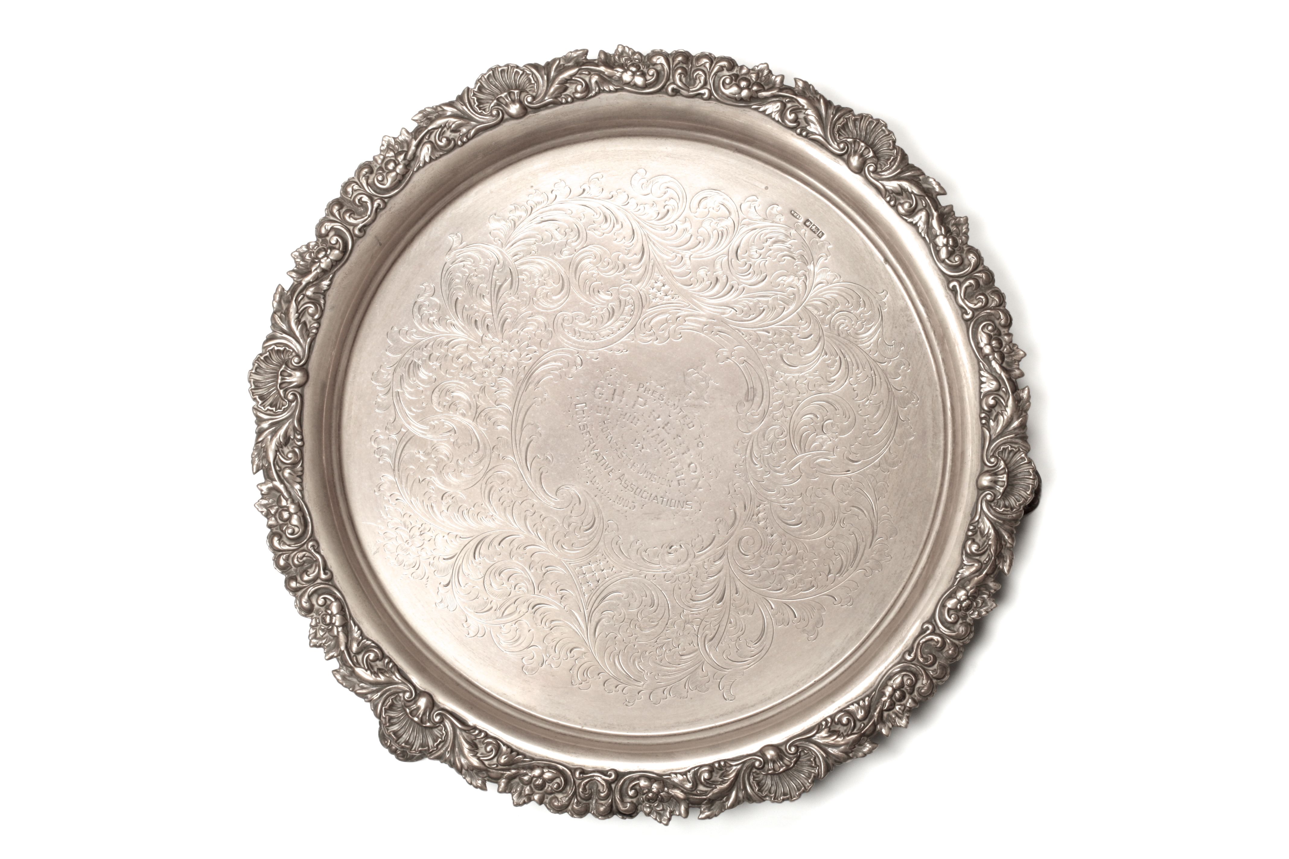 An Edwardian silver salver with flower embossed rim, hallmarked Sheffield 1902, the centre engraved