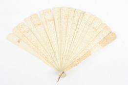 A Chinese ivory fan, the guard stick carved with images of figures, temples and flowers, the inner