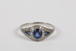 An Art Deco white gold, sapphire and diamond ring, the central oval sapphire with triangular
