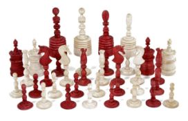 An early 20th century carved and stained bone chess set, with unstained and red stained pieces, of