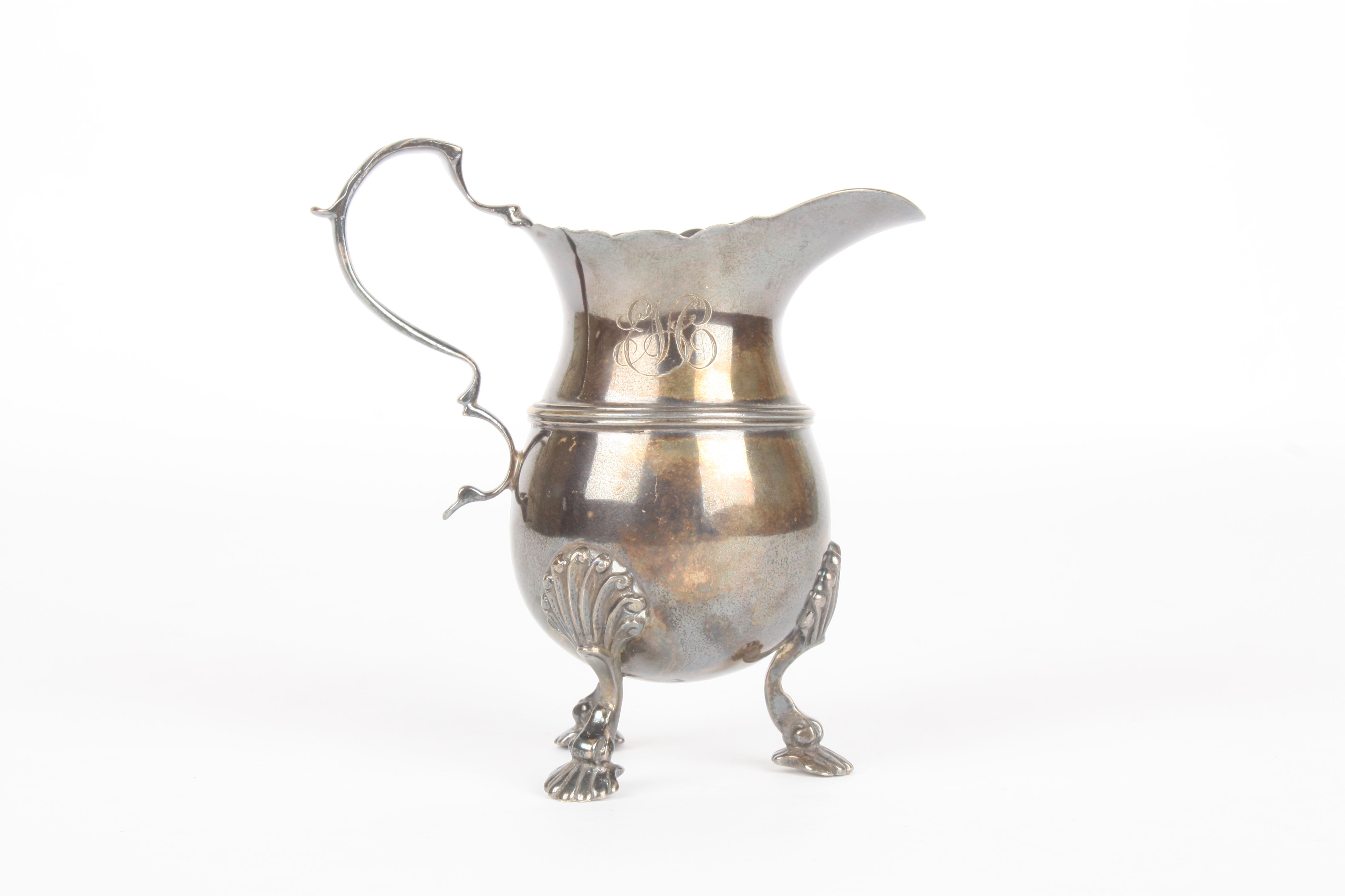 An Irish silver milk jug, hallmarked Dublin 1914, the bulbous body with scrolled handle and