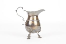 An Irish silver milk jug, hallmarked Dublin 1914, the bulbous body with scrolled handle and