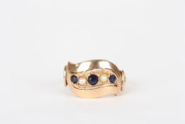 A gold coloured metal sapphire and seed pearl ring, three faceted sapphires and two seed pearls in