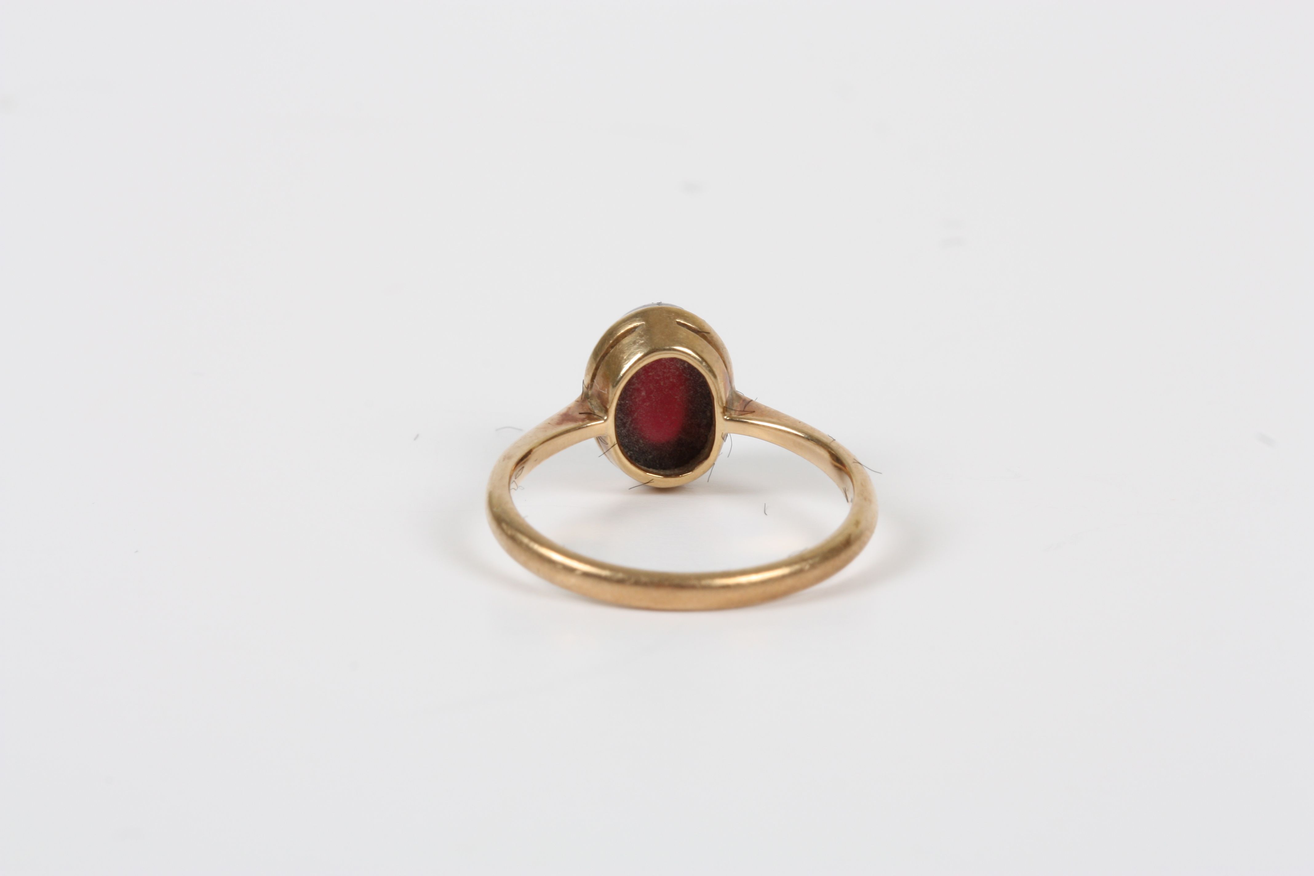 A 9ct gold and cabochon garnet ring, with rub over setting, size K½  Good condition. - Image 2 of 2