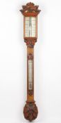 A Victorian carved oak wide tube stick barometer by Dollond of London, with carved oak leaf and