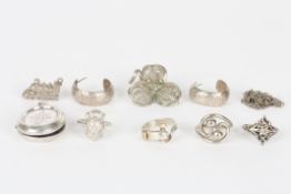A collection of silver jewellery, comprising four rings, a pair of half hoop earrings, a brooch, a