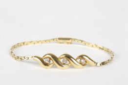 A gold coloured metal bracelet with three diamonds, in swirl setting, on flexible bracelet, length