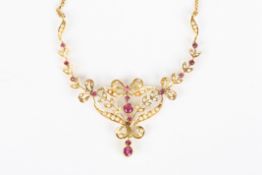 An Edwardian style gold coloured metal necklace, set with rubies and seed pearls on chain link