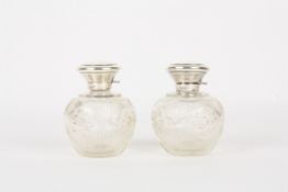 A pair of George V silver topped scent bottles, hallmarked London 1920 with cut glass bodies and