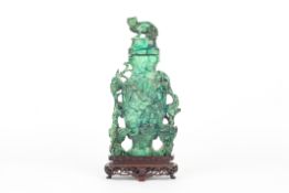 A late 19th/early 20th century Oriental malachite vase and cover, heavily carved and pierced with