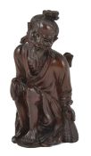 A Chinese carved hardwood figure of an elder, circa 1900, the man in seated position with a basket