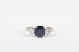 An 18ct white gold diamond and sapphire ring, set centre step cut sapphire with diamonds to sides,
