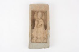 A Chinese carved stone tablet, deeply recessed and depicting a seated deity with hand raised, 30cm