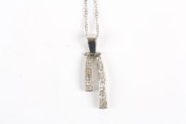 A Modern white gold coloured metal and diamond drop pendant, with two drops of differing lengths