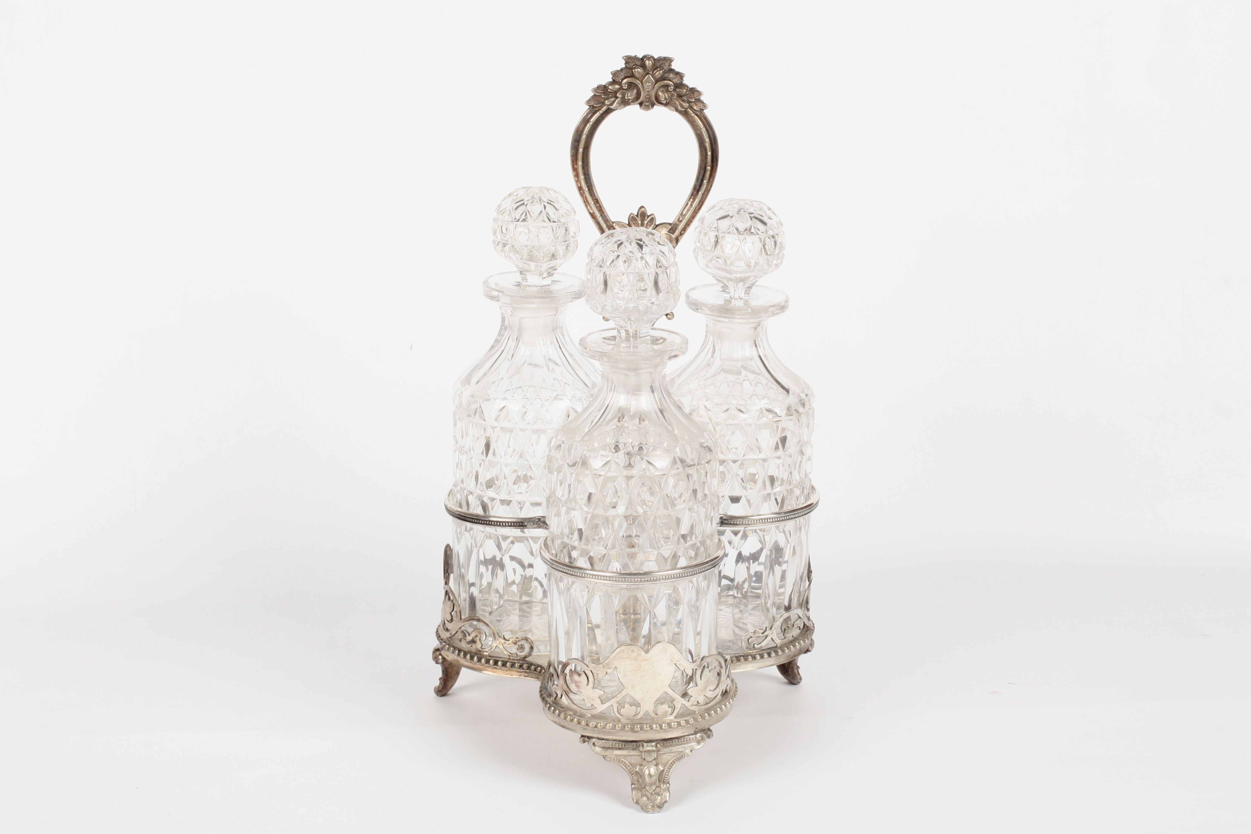 A Victorian silver plated trefoil decanter stand, with three cut glass decanters and stoppers. The