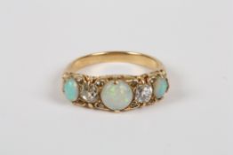 A Victorian gold coloured metal ring set with opals and diamond, the five stone ring set with three