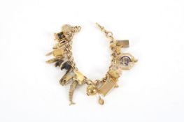 An 18ct gold charm bracelet with unusual selection of over 20 9ct gold charms, the 18ct gold curb