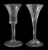 Two 18th century drinking glasses, both with flared trumpet shaped bowls, plain stems and rough