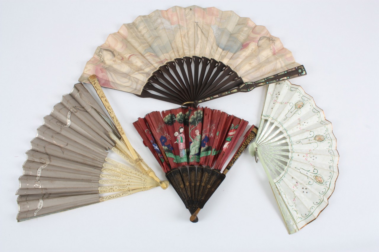 A collection of four fans, one with guard sticks inlaid with mother-of-pearl and silk fan with