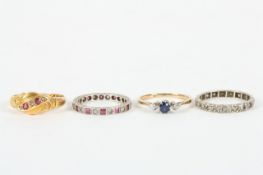 Four rings, including a three stone set with two diamonds and centre sapphire, five stone ring set
