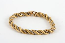 An 18ct gold rope twist bracelet, intertwined with chain link white coloured metal length 19.5cm,