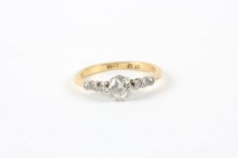 An 18ct gold diamond ring, set with approximately 1/4 carat diamond and six diamonds to shoulders In