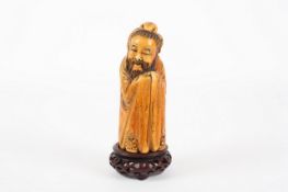 A Chinese carved ivory figure of an immortal, late 18th / early 19th century, the figure with jovial