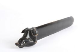 An ebonised page turner in the form of a boars head, with glass eyes, and tusk. 40cm long One tusk