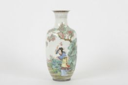 A Chinese famille rose 20th century vase, of baluster form with ladies amongst trees, foliage and