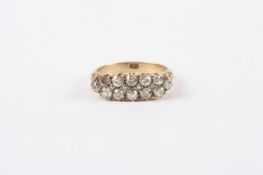 A Victorian 18ct gold twelve stone diamond ring, with old cut diamonds, carved shoulders and claw