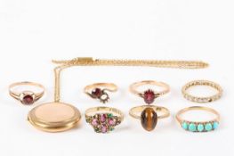 A collection of seven rings and a locket, comprising a Victorian red and green garnet ring, a five