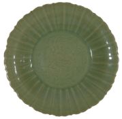 A 19th century Chinese clay celadon large fluted dish, with incised floral decoration to the centre.