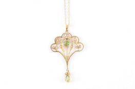 An Edwardian 9ct gold shield shape drop pendant, set with two peridot and numerous seed pearls on