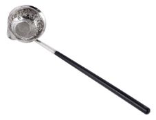 A silver shilling ladle, with tapered ebonised handle, the bowl embossed with floral decoration.