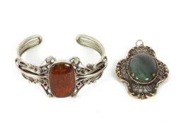 An amber and silver plated stiff bracelet, the amber set within a silver plated mount on a