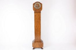 A 1930s walnut grandmother clock, the circular dial with central walnut roundel, the movement with