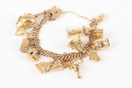 A double link 9ct gold charm bracelet, with 15 charms including a ship in a bottle, a seal, a Buddha