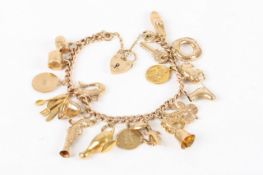 A 9ct gold curb link charm bracelet, with padlock clasp and approximately 20 gold charms attached,