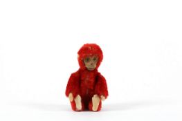 A red Schuco monkey with hidden perfume bottle, with red fur and velvet pads, the head lifting up to