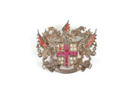A silver ruby and diamond brooch in the form of a crest, the centre set with a ruby cross surrounded