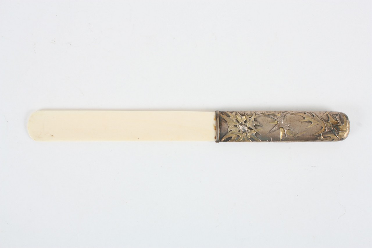 A late 19th century/early 20th century ivory page turner, the handle with silver coloured metal