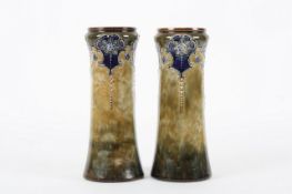 A pair of Royal Doulton stoneware vases, the tubular shaped vases with typical blue decoration on