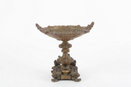 A Victorian brass tazza, decorated all over in relief with scenes of cherubs, masks, ribbons and