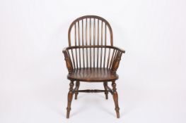 An elm and oak stick back Windsor chair, with shaped elm seat and supported on turned front legs.