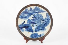 A Chinese blue and white circular dish, circa 1900, decorated with trees and pagodas in a landscape.