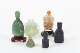 A collection of six Chinese perfume bottles, including three carved jade bottles, two lapis